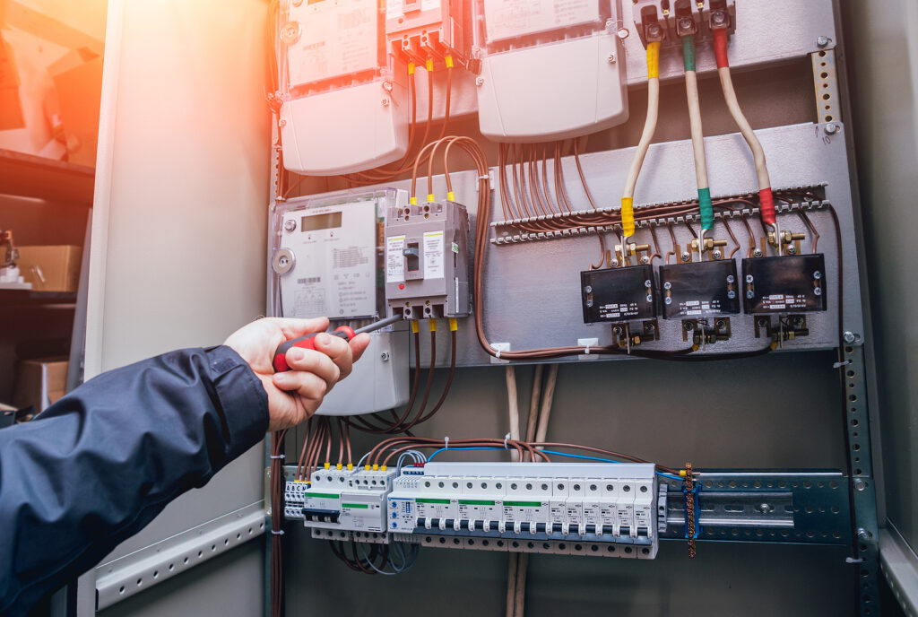 An electrician testing and tagging on a switchboard upgrade.